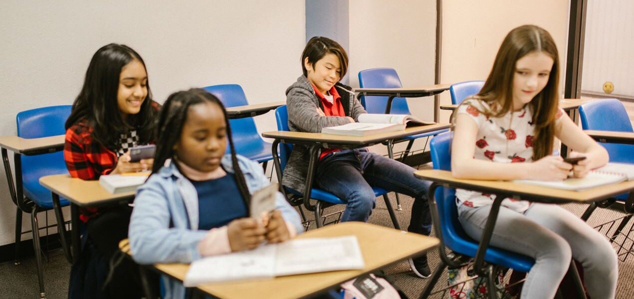 Grupo de jovenes sentados en un pupitre en un aula escolar