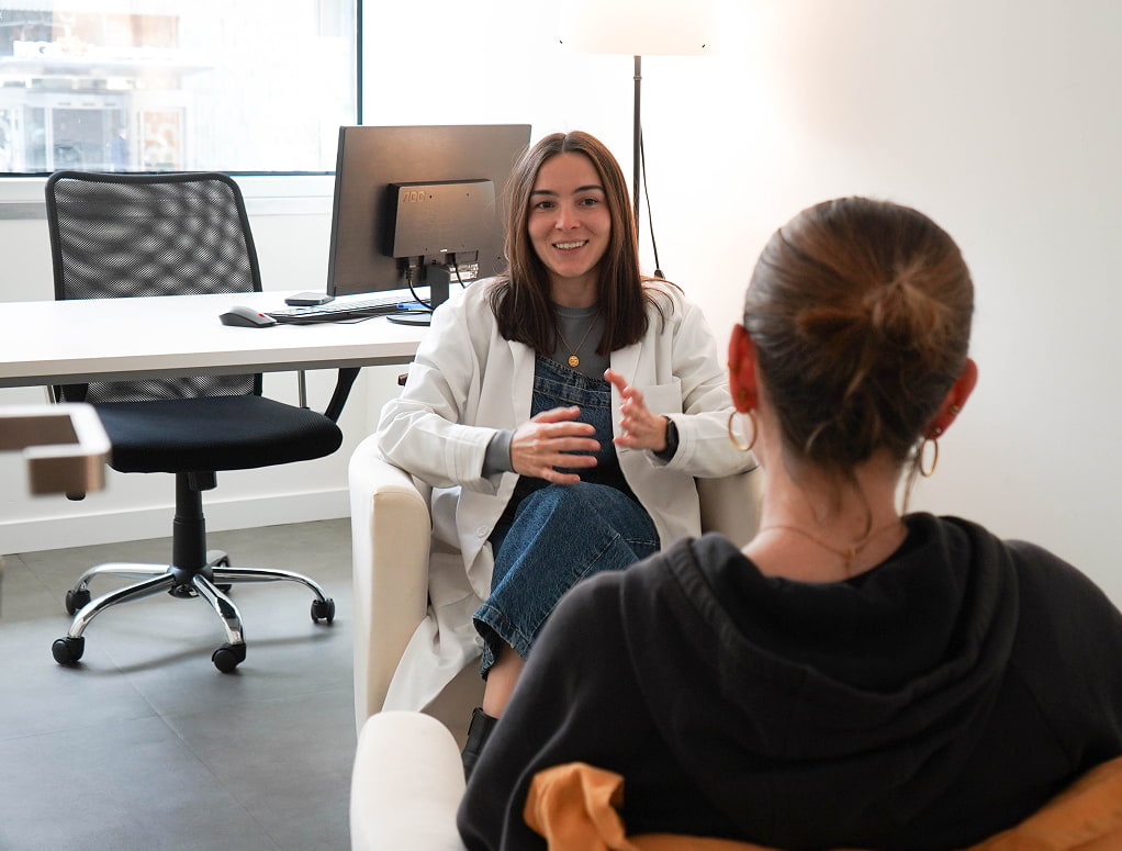 Una joven adolescente en consulta con una sonriente profesional
