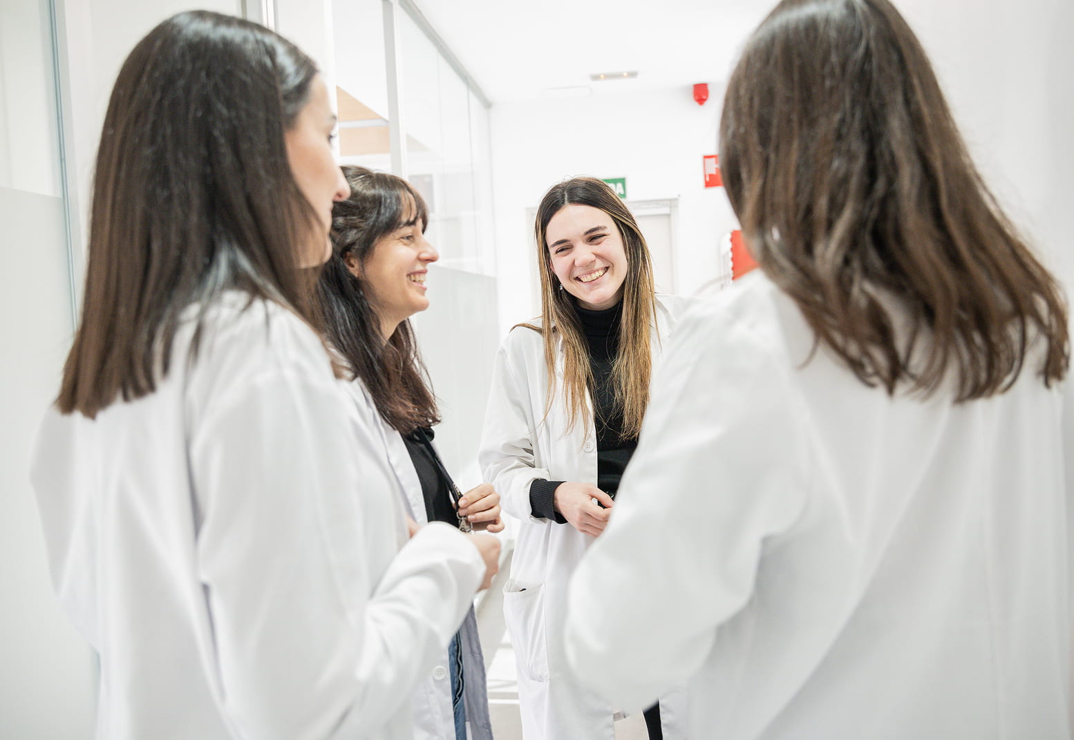 Grupo de profesionales en bata sonriendo y manteniendo una conversación