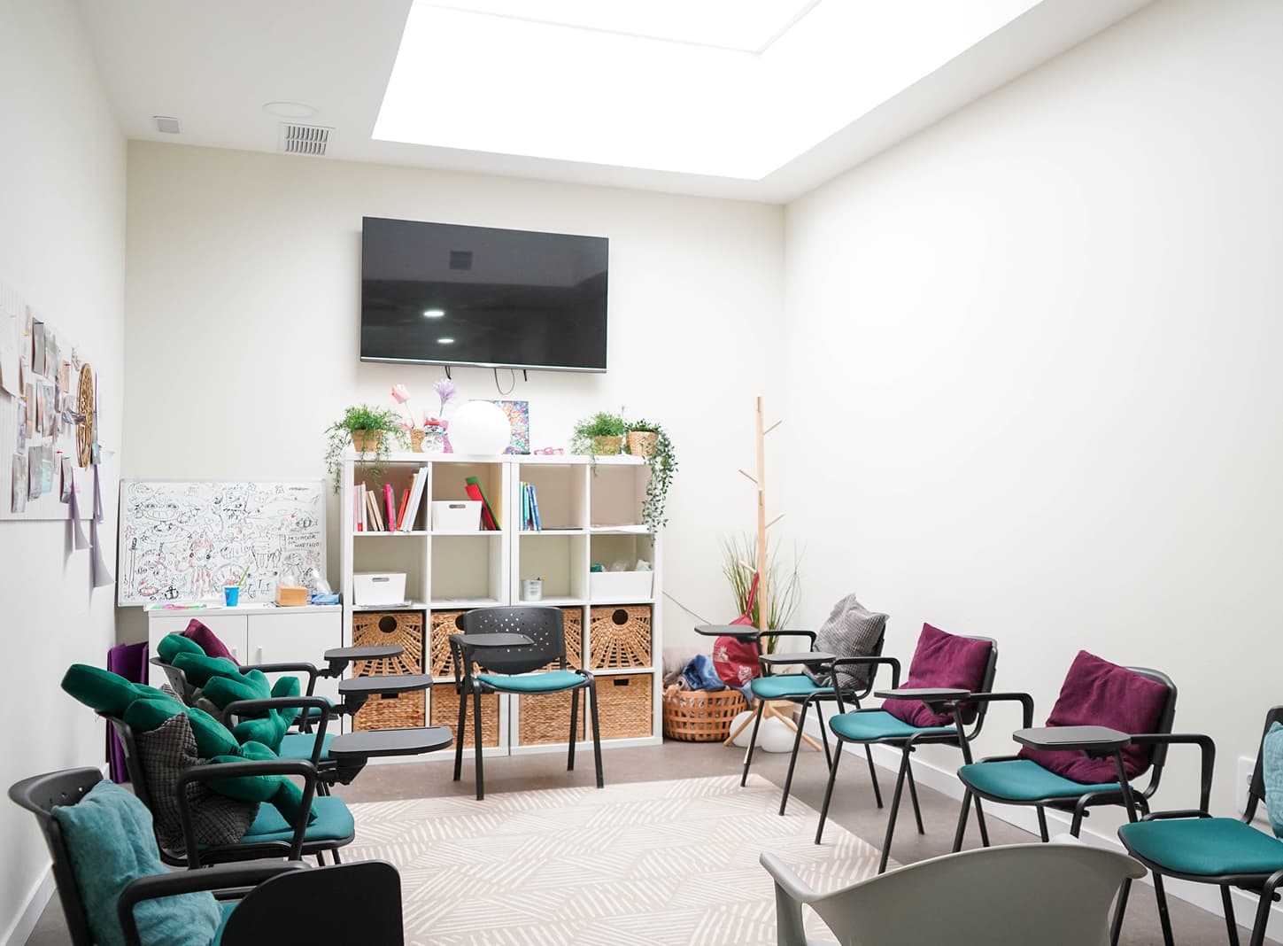 Sala polivalente de sillas verdes y un tragaluz luminoso