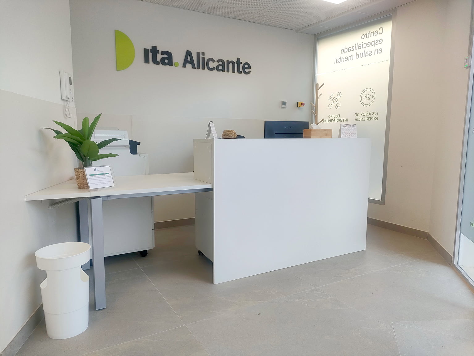 Infraestructura de recepción con el logo de Ita y una planta