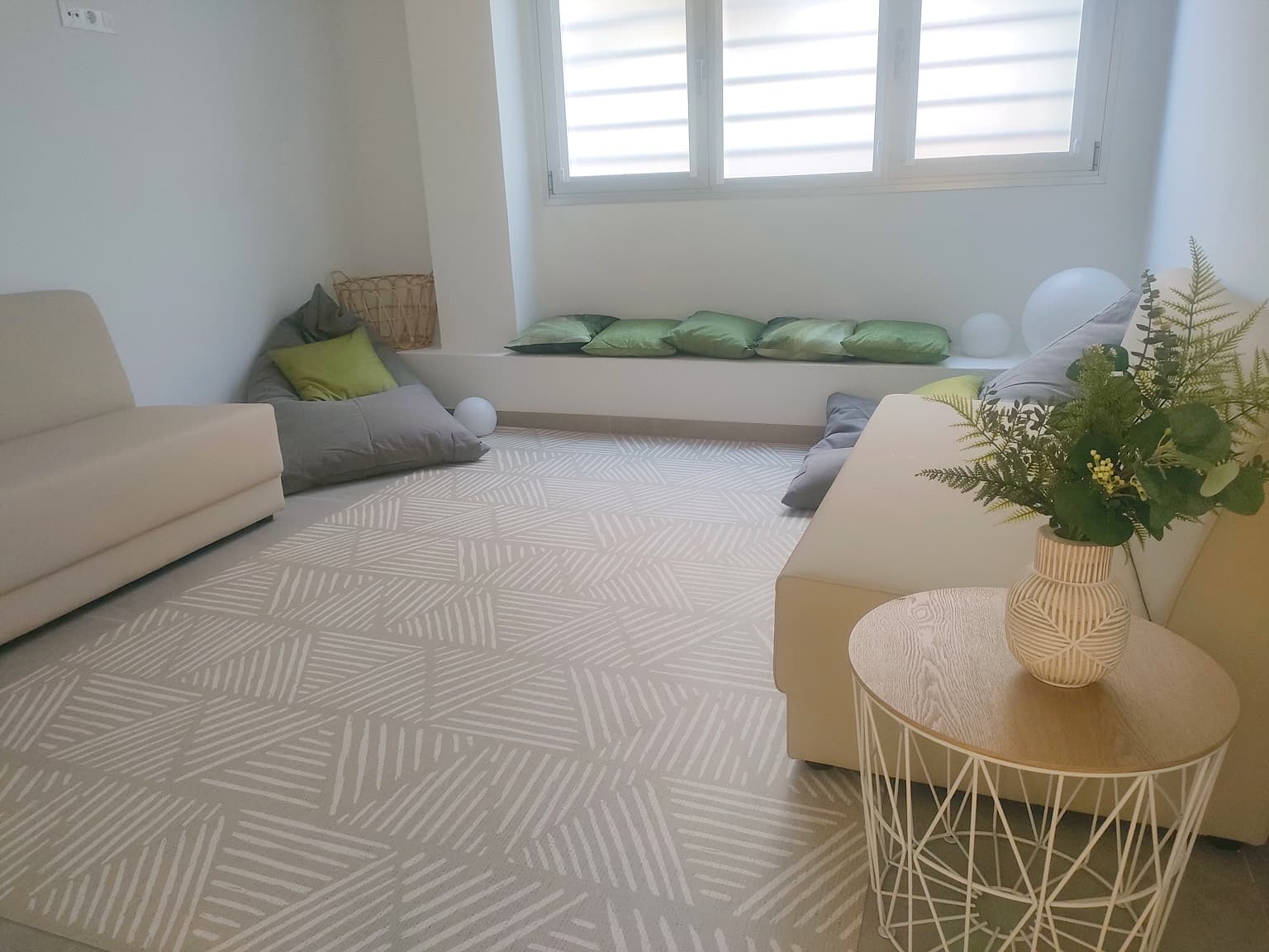 Espacio de reuniones y  juegos con butacas bajas, cojines y alfombra