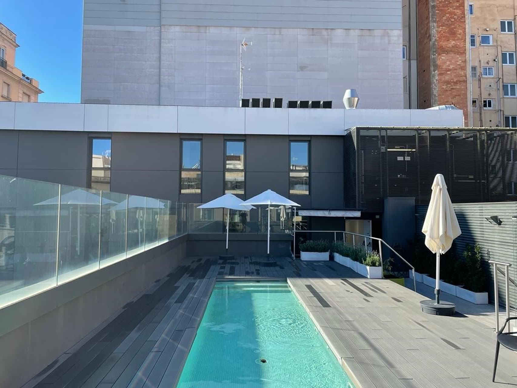 Piscina descubierta con zonas para sentarse y tomar sol