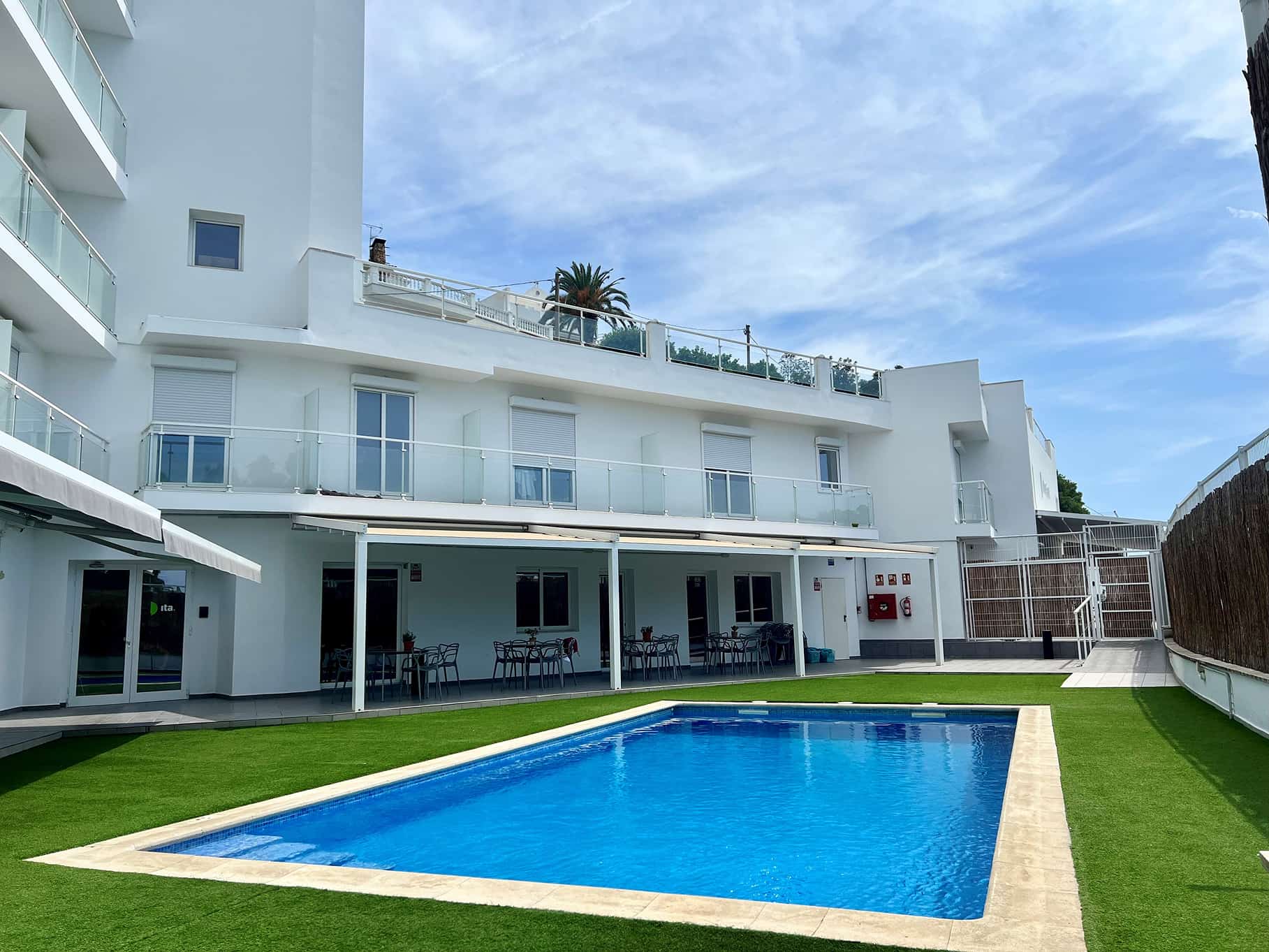 Piscina y fachada de un edificio blanco de varias plantas