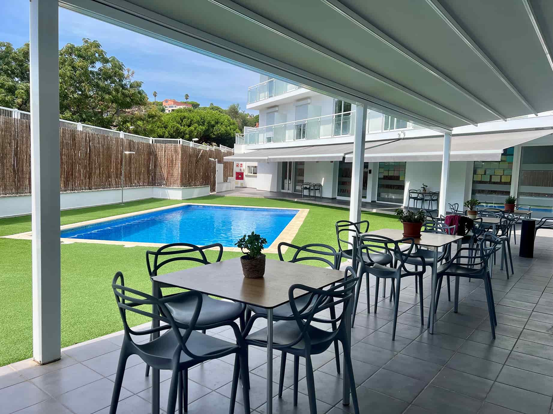 Jardín exterior compuesto por piscina y zonas para sentarse
