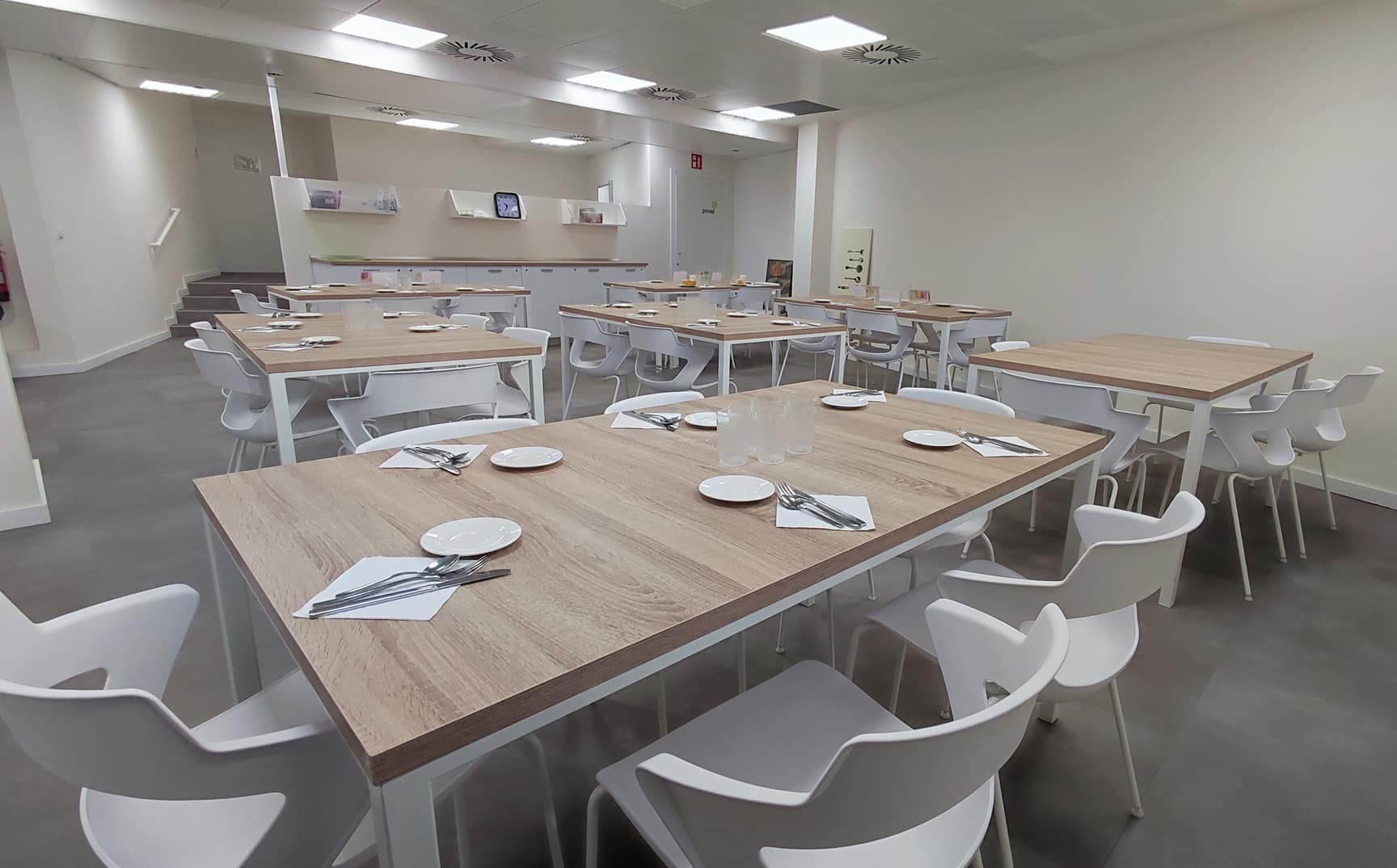 Comedor con varias mesas vestidas de platos