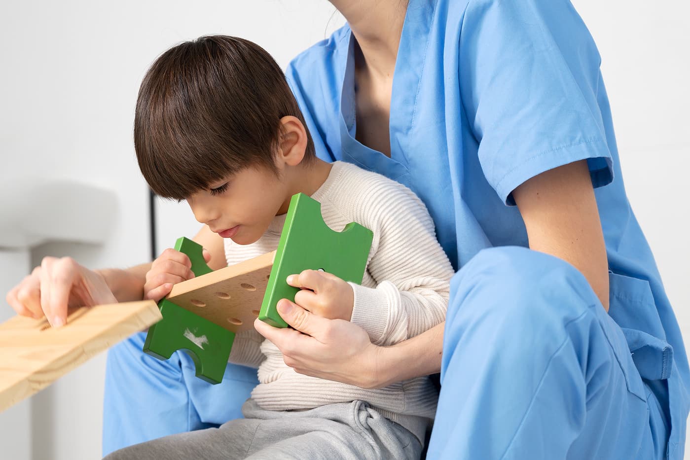 Niño realizando una actividad educativa acompañado por una cuidadora
