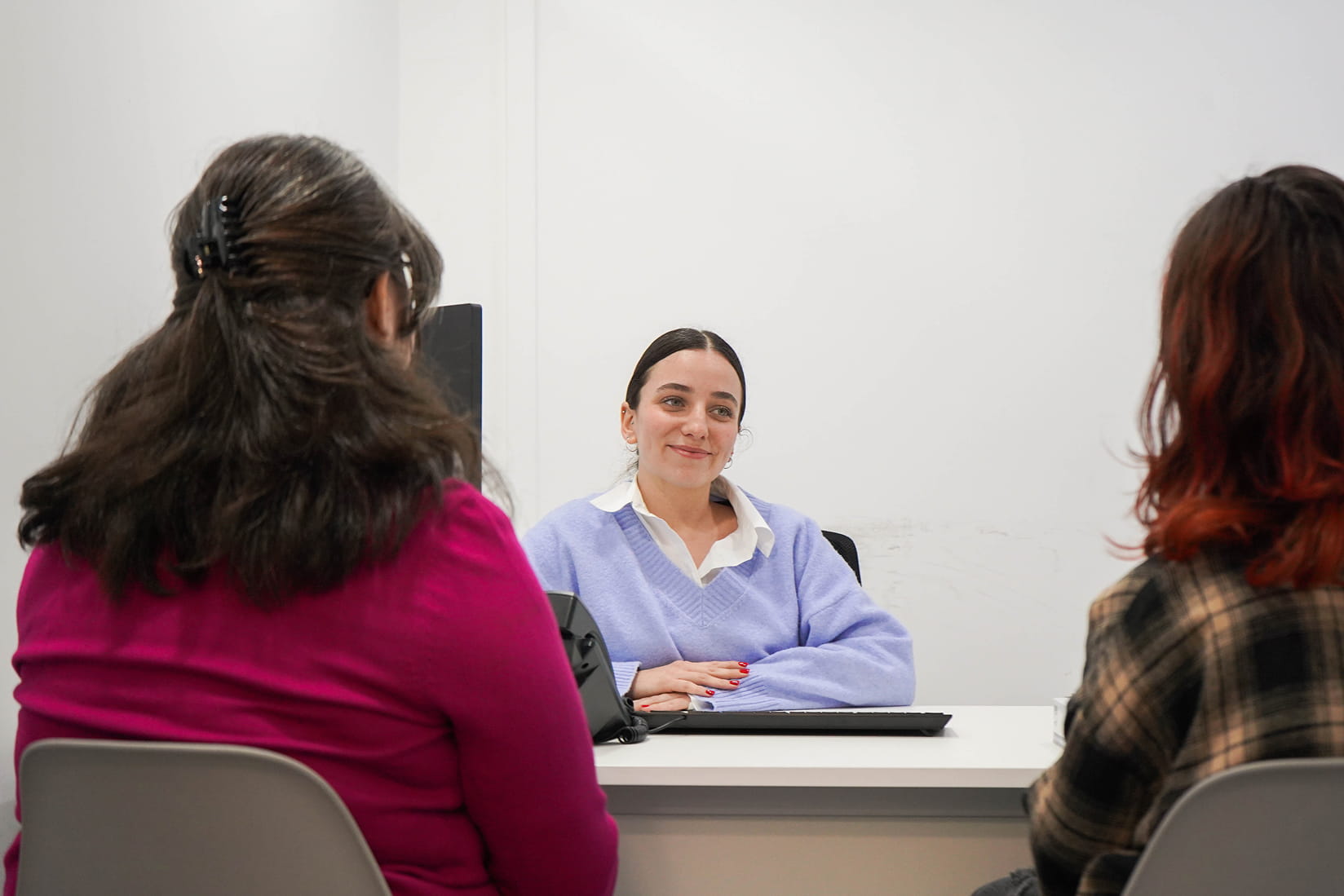 Psicóloga conversando con dos pacientes durante una sesión