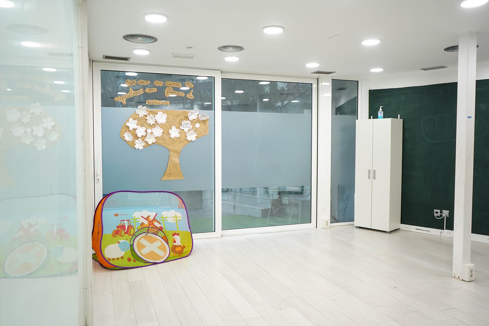 Sala de psicología infantil con pizarra y materiales para actividades terapéuticas