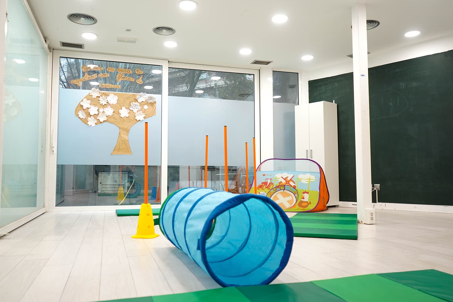 Sala de psicología infantil con pizarra y materiales para actividades terapéuticas
