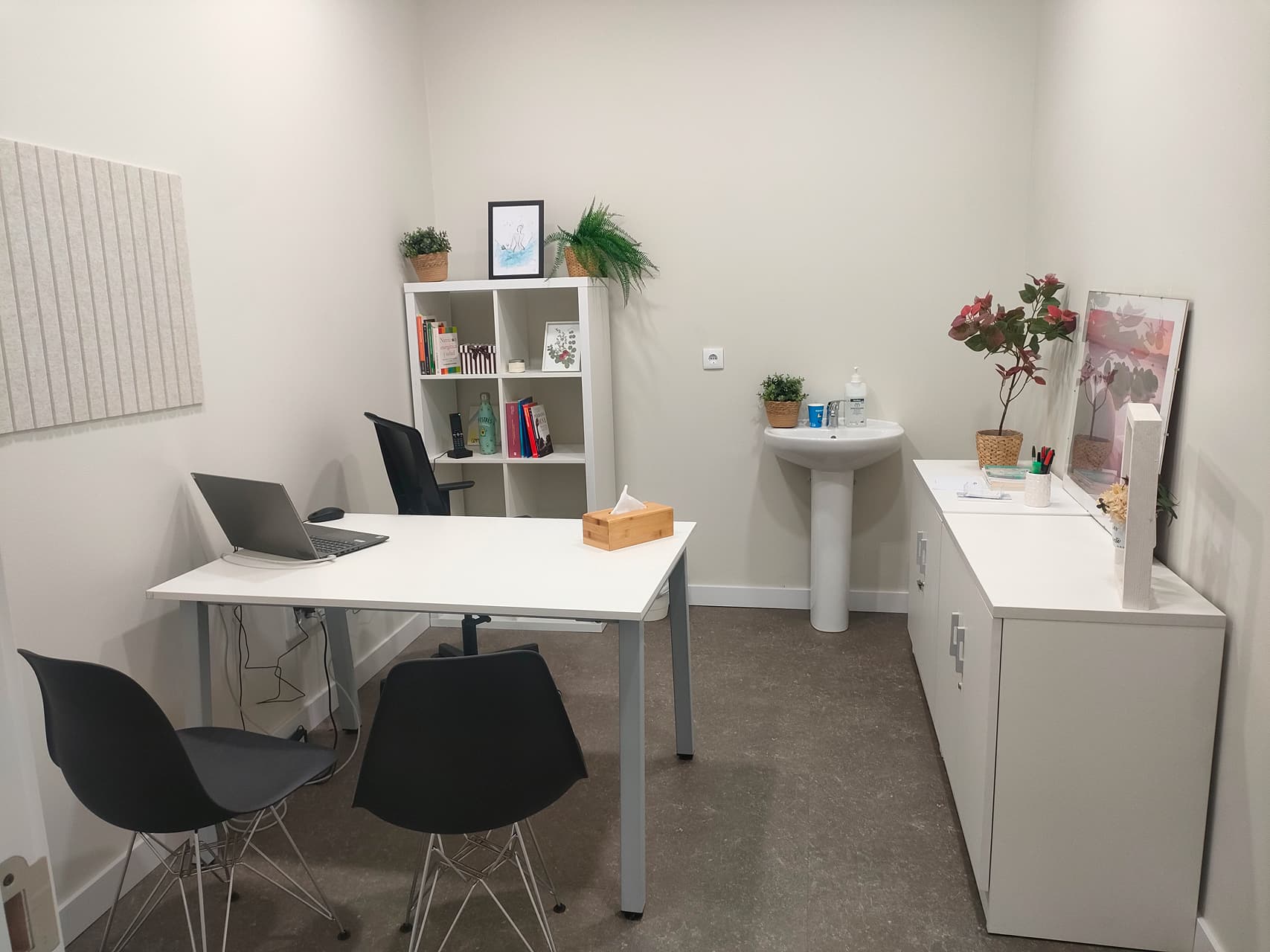 Consulta de psicología infantil con escritorio, sillas y material educativo