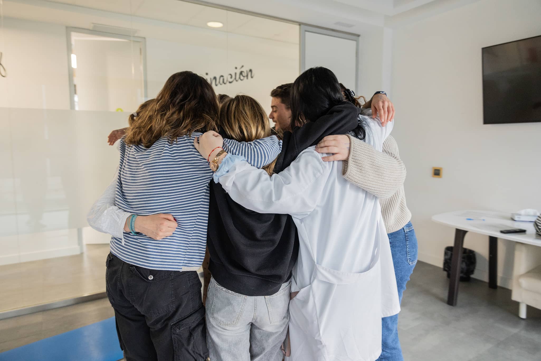 Psicóloga y pacientes compartiendo un abrazo en grupo