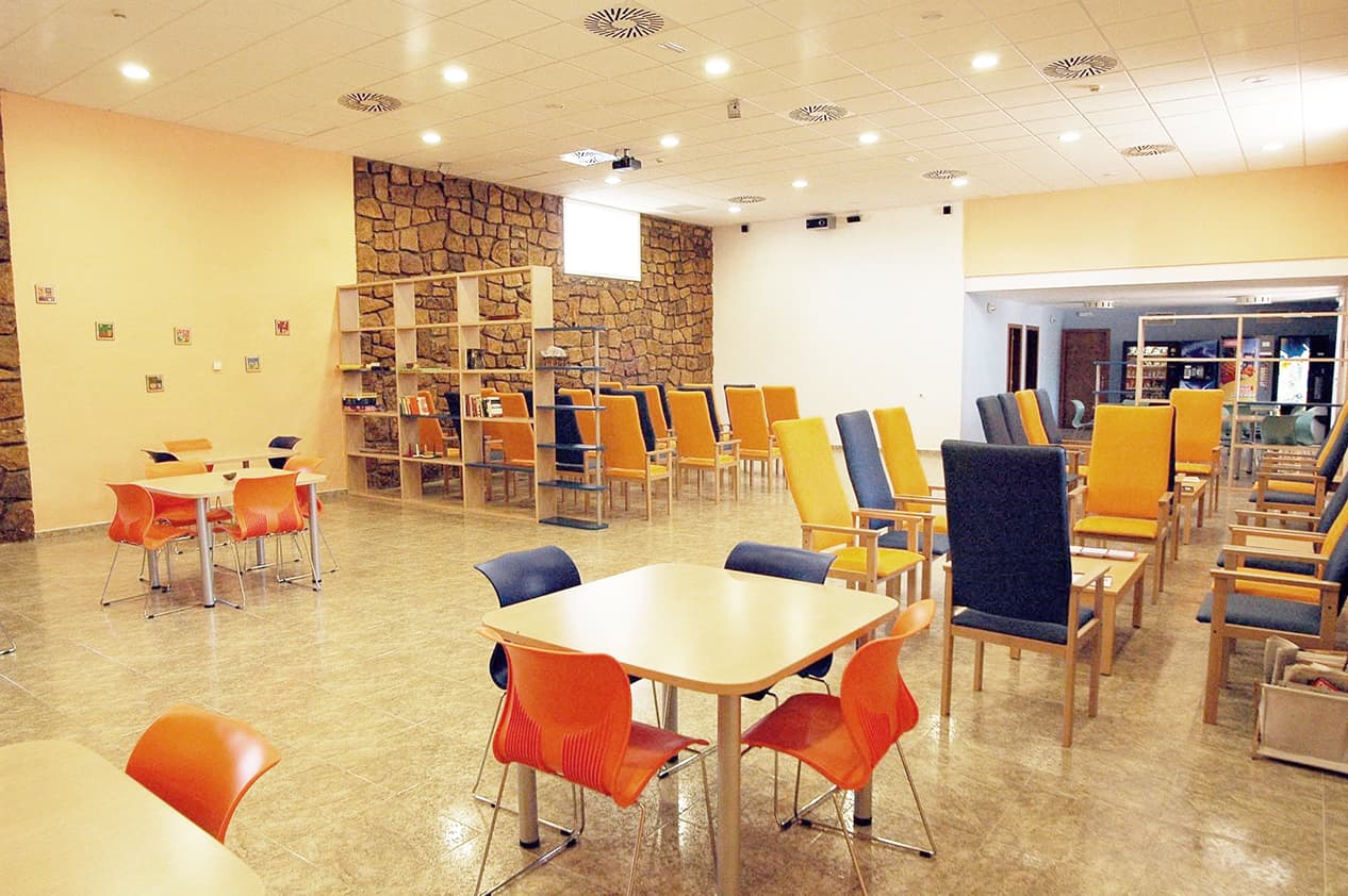 Sala común de Ita San Juan con mesas, sillas y zona de lectura