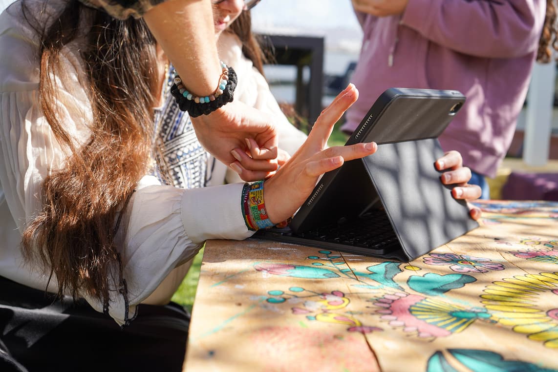 Personas utilizando una tablet durante una actividad grupal al aire libre
