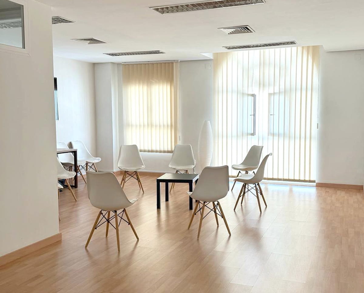 Sala de actividades de Ita Sevilla con sillas y luz natural