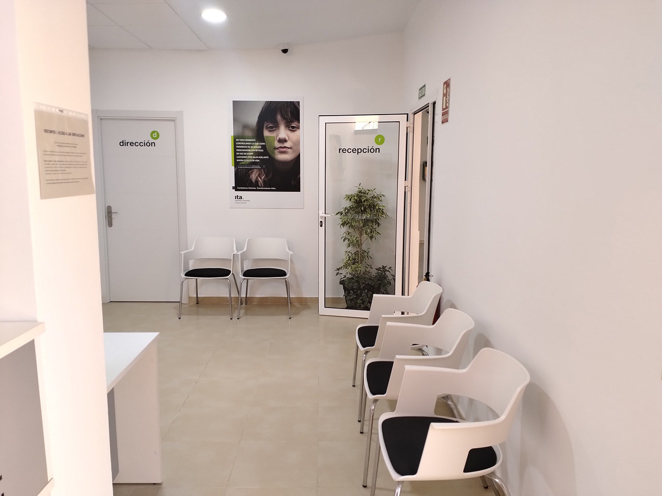 Sala de espera con sillas y paredes blancas