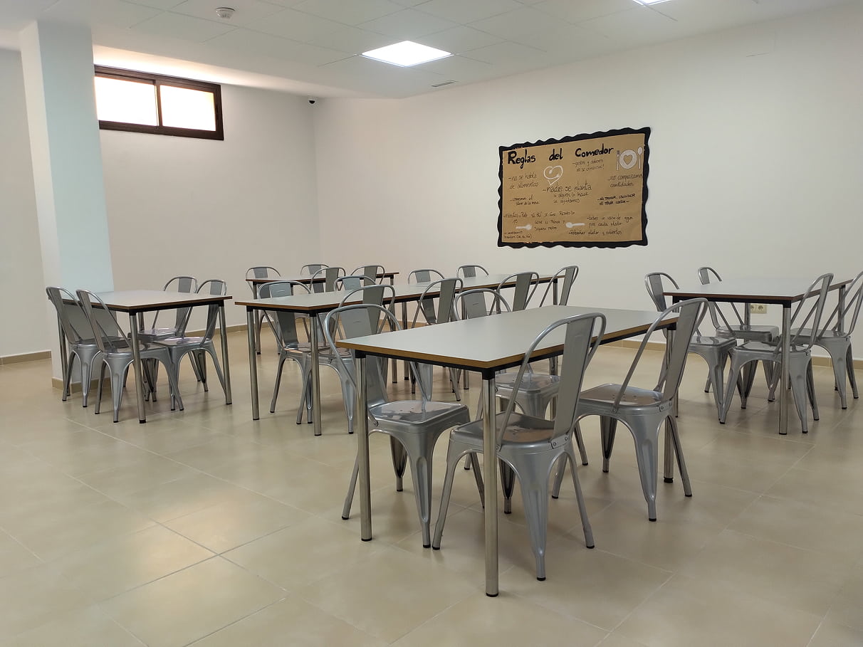 Zaona común de comedor con mesas y sillas y una pequeña ventana