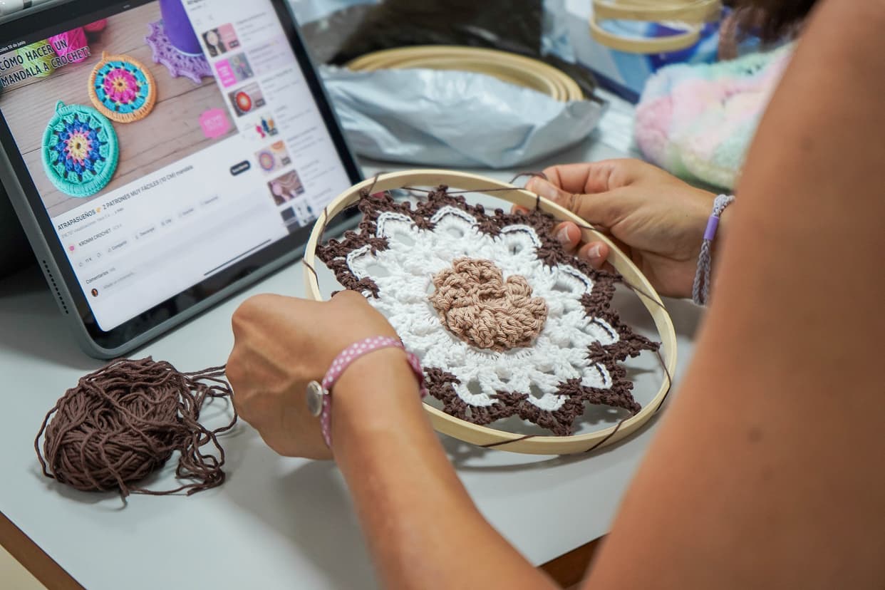 Persona realizando una actividad de crochet con una tablet