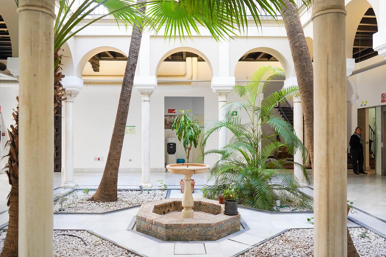 Patio interior de Ita Vidrio con palmeras, fuente y columnas
