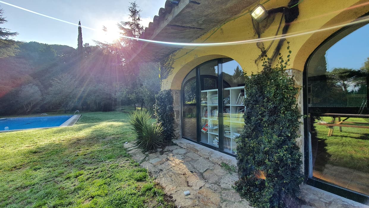Esquina de casa baja rodeada de vegetación y una piscina