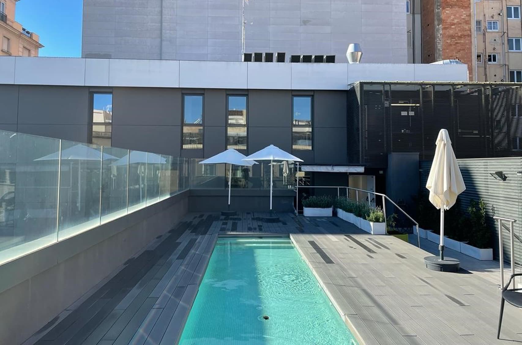 Piscina descubierta con zonas para sentarse y tomar sol