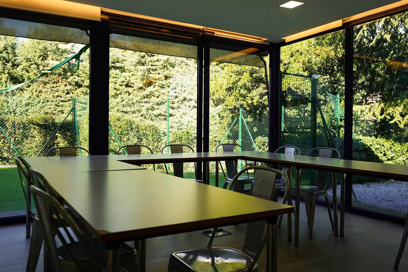 Comedor de Ita Mirasierra con mesas amplias y ventanales que exhiben el jardín