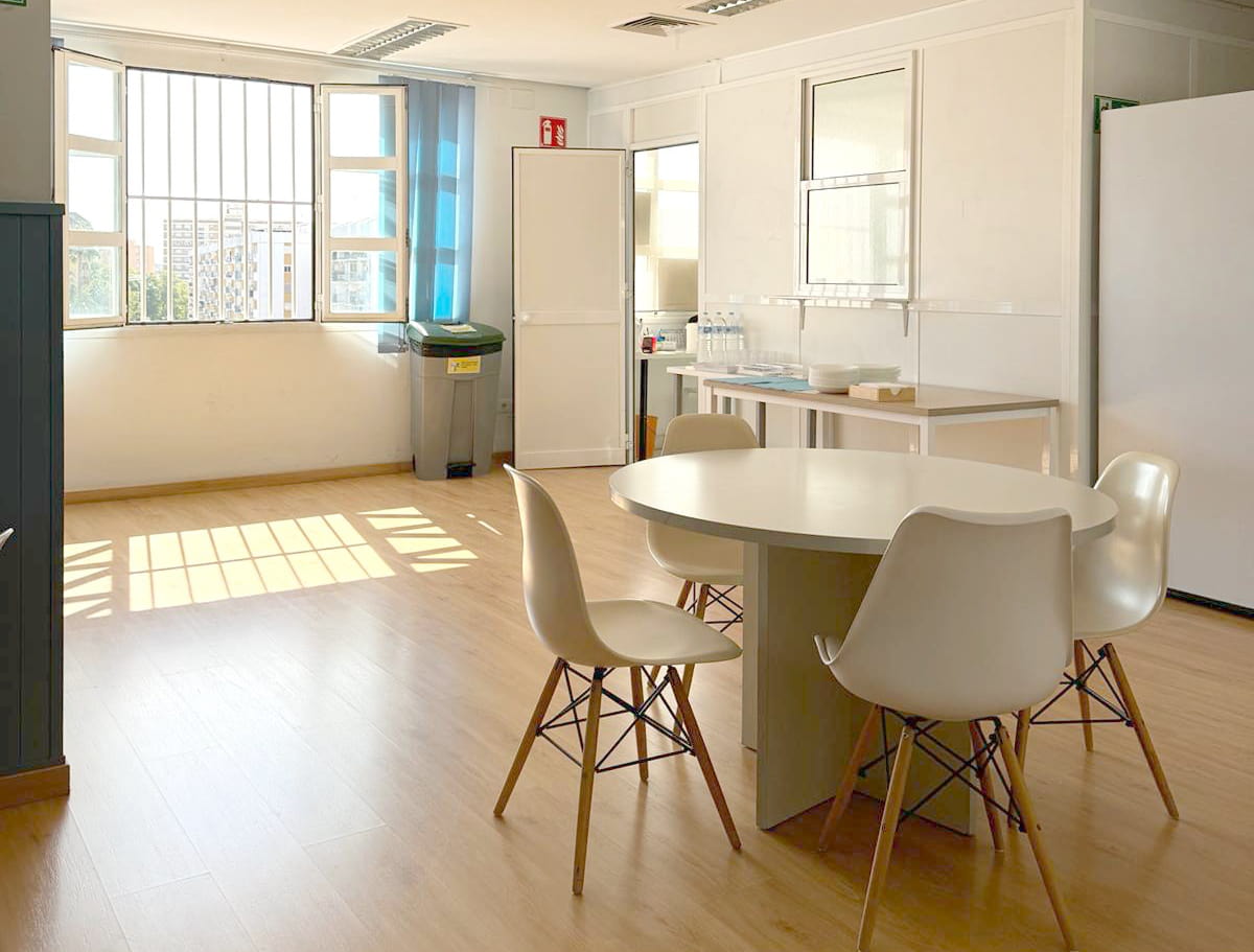 Salón comedor con mesa redonda y ventana en Ita Sevilla HD
