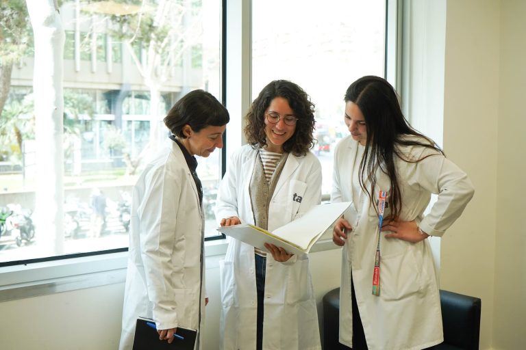 Tres profesionales en bata revisando documentación